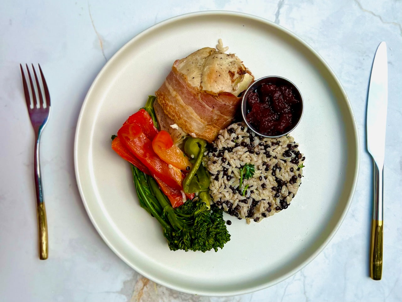 Poitrine de poulet farcie aux pommes et cheddar ontarien vieilli, enrobée de bacon, accompagnée d'un pilaf de riz et lentilles