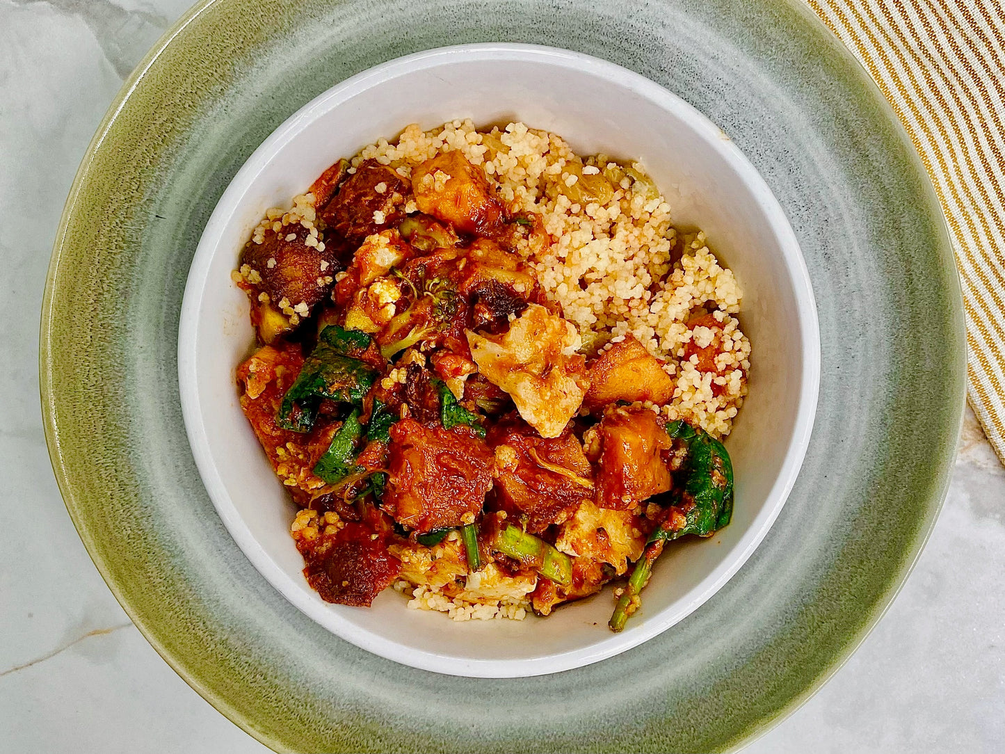 Tajine de légumes, sauce harissa, couscous bio aux pois chiches, aux raisins secs et aux oignons verts