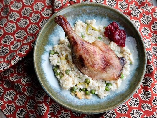 Cuisses de canard braisées et leur sauce aux airelles, risotto crémeux aux poireaux et petits pois