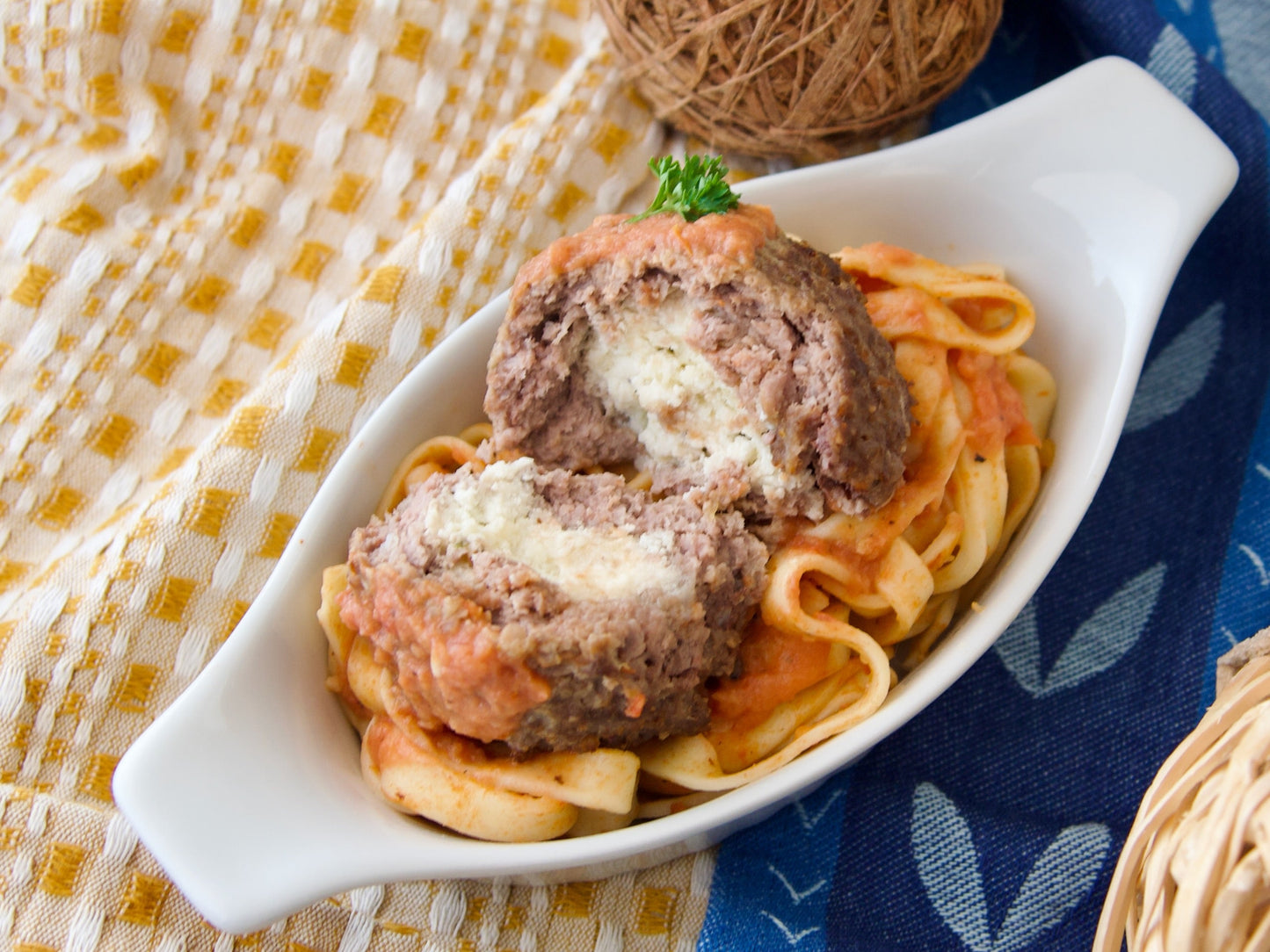 Énorme boulette de bœuf « Enright » farcie à la ricotta, servie avec des spaghettis, une sauce tomate et du parmesan