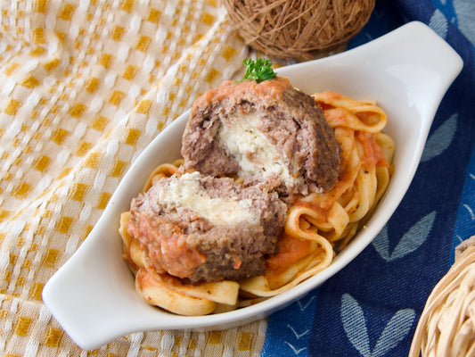 Énorme boulette de bœuf « Enright » farcie à la ricotta, servie avec des spaghettis, une sauce tomate et du parmesan